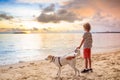 Child and dog playing on tropical beach Royalty Free Stock Photo