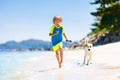 Child and dog playing on tropical beach Royalty Free Stock Photo