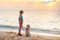 Child and dog playing on tropical beach Royalty Free Stock Photo