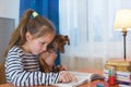 Child with dog reading book at home. Girl with pet sitting at window at read