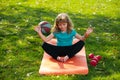 Child doing exercise outdoors. Healthy kids lifestyle. Yoga children in park doing yoga asana. Lifestyle relaxation