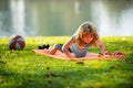 Child doing gymnastic exercises, sportive kid doing push ups on fitness mat in nature. Boy doing push-ups in the yard Royalty Free Stock Photo