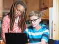 Child doing homework with foster parent in kitchen Royalty Free Stock Photo