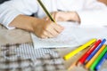 Child doing homework and writing story essay. Elementary or primary school class. Closeup of hands and colorful pencils Royalty Free Stock Photo