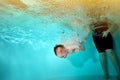 A child with Down syndrome dives to the bottom of the pool during a sports class, and the trainer-instructor insures him