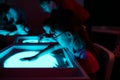 Child with Down syndrome is engaged in sand therapy on a light table