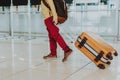 Child is dragging big orange suitcase inside Royalty Free Stock Photo