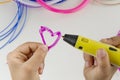 Child draw with 3D pen. Colourful filaments and white background