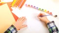 Child drawing with color paints. Top view of child hands with brush. Painting picture on paper. Back to school. Color pencils, Royalty Free Stock Photo