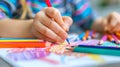 Child drawing with colored pencils on colorful paper, close-up Royalty Free Stock Photo