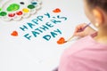 Child is drawing Father`s day greeting card