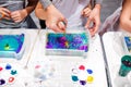 Child drawing with needle on the water. Ebru art is a method of aqueous surface design