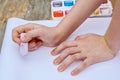 Child is drawing a picture on white paper with a colorful chalk Royalty Free Stock Photo