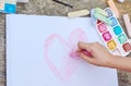 Child is drawing a picture on white paper with a colorful chalk Royalty Free Stock Photo