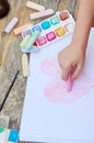 Child is drawing a picture on white paper with a colorful chalk Royalty Free Stock Photo