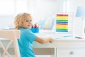 Child drawing rainbow. Kid painting at home