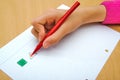 Child drawing a red triangle and a green square Royalty Free Stock Photo