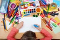 Child drawing top view. Artwork workplace with creative accessories. Flat lay art tools for painting. Royalty Free Stock Photo