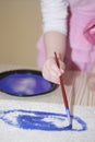 The child draws a blue paint