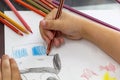 Child draws with colorful pencils. Children`s drawing on theme of fishing with goldfish, car Royalty Free Stock Photo