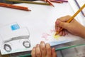 Child draws with colorful pencils. Children`s drawing on theme of fishing with goldfish, car Royalty Free Stock Photo