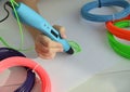 Child draws a 3D pen green leaf.