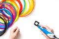 Child draws 3Dpen. Colorful rainbow plastic filaments for 3D pen laying on white. New toy for child. Royalty Free Stock Photo