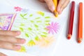 The child draws flowers for mom with pencils. Baby gift. White background