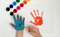 The child draws his hand with blue paint and a brush. Finger painting or art therapy for children Royalty Free Stock Photo