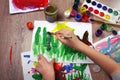 The child draws with paints. Children`s drawings. child`s hand with brush and drawings. watercolor paint. children`s creativity. t
