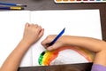 Child draws paints on a paper. Children& x27;s hands in kindergarten painting hearts with temperas and a brush on a sheet Royalty Free Stock Photo