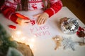 Child draws santa claus on christmas letter with inscription dear santa.