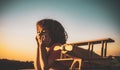 Child dreams and imagination concept. Dreaming child playing with toy wooden airplane against summer sky background Royalty Free Stock Photo