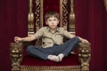 Child dreams in a royal red chair