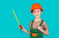 Child dressed as builder with ruller in hands. Child dressed as a workman builder. Little boy wearing helmet. Little