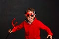 Child dressed in devil costume with red pitchfork in his hands in image devil Royalty Free Stock Photo