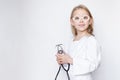 Child dressed up in doctor uniform with toy eyeglasses holding stethoscope, looking at camera, half lenth portrait, copy space