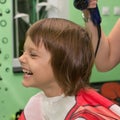 Child dries the hair in a hair salon