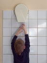 Child dries hands in an electric hand dryer