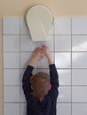 Child dries hands in an electric hand dryer