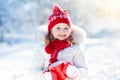 Child drinking hot chocolate in winter park. Kids in snow on Christmas. Royalty Free Stock Photo