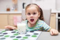 Child drinking milk in the kitchen at home