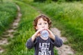 Child drinking pure water in nature. Cute curly toddler Royalty Free Stock Photo