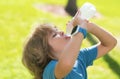 Child drinking water. Kid enjoy pure fresh mineral water. Outdoor kid boy drinking pure bottle from glass. Close up