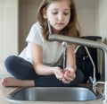 Child drinking water in kitchen at home. Thirsty baby. Hands open for drinking tap water. Pouring fresh drink. Water quality check Royalty Free Stock Photo