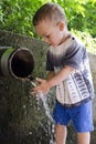 Child at drinking water pipe fountain. Royalty Free Stock Photo