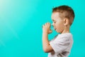 child drinks water on a turquoise background
