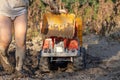 A child drives a large dump truck on dirty soil. Feet, children`s hands and a dump truck in the mud. Royalty Free Stock Photo