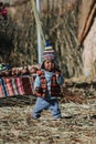 Child on dry bamboo plants of Uros Island, Peru. Uru or Uros - indigenous people of Peru and Bolivia