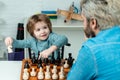Child early development. Concept of education and teaching. Happy family. Teacher helping young boy with chess. Back to
